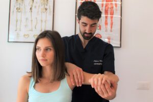 osteopata che tratta la spalla della paziente