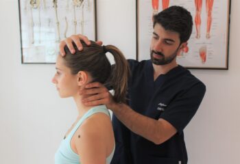 osteopata che valuta la cervicale di una paziente