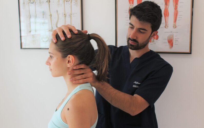 osteopata che valuta la cervicale di una paziente