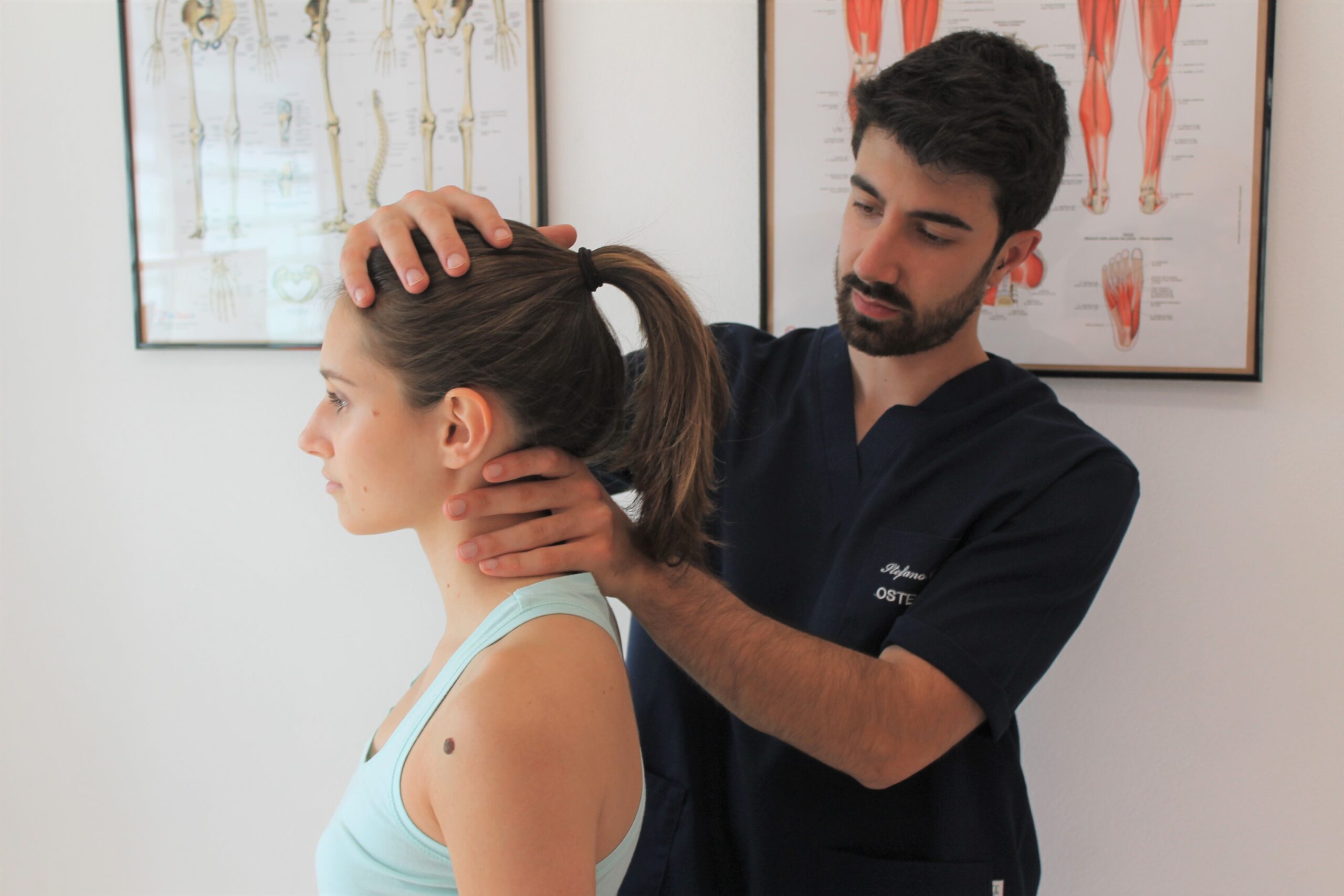 osteopata che valuta la cervicale di una paziente