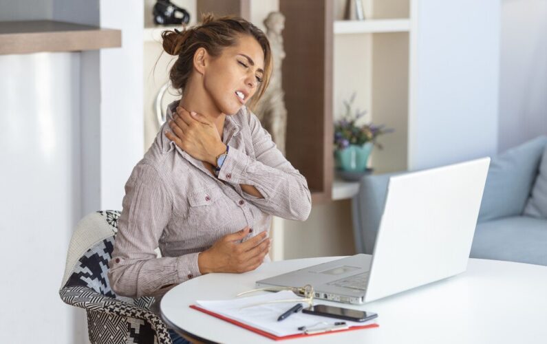 donna che si tocca il collo per il dolore nel lavorare a pc