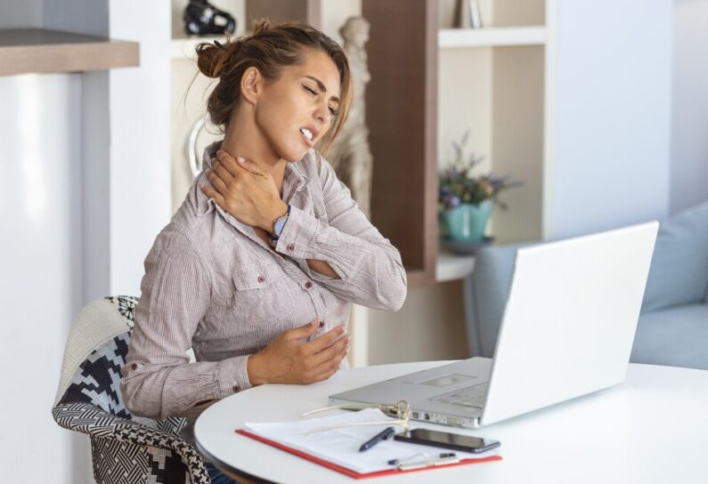 donna che si tocca il collo per il dolore nel lavorare a pc