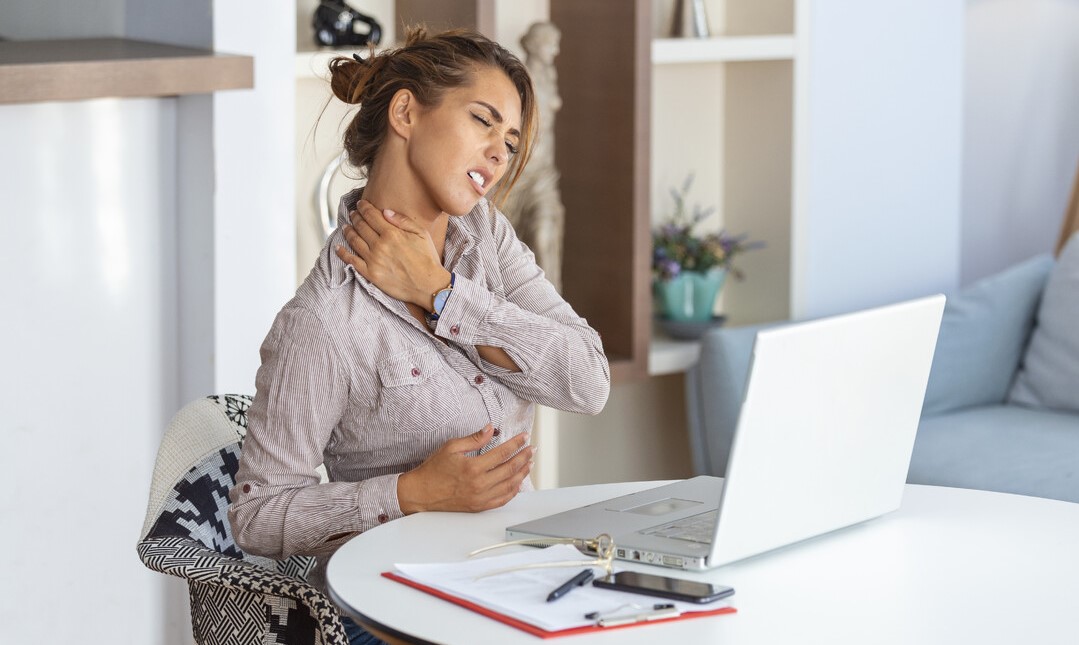 donna che si tocca il collo per il dolore nel lavorare a pc